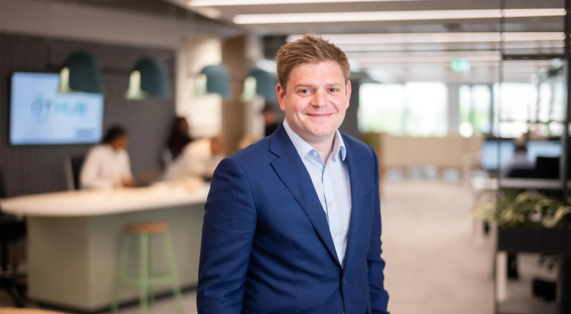 James Corrigan, UK Managing Director, Infrastructure, smiling in a softly lit office interior