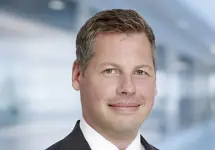 Portrait of Gavin Steele Director, Global Head of Aviation standing in blurred office background.