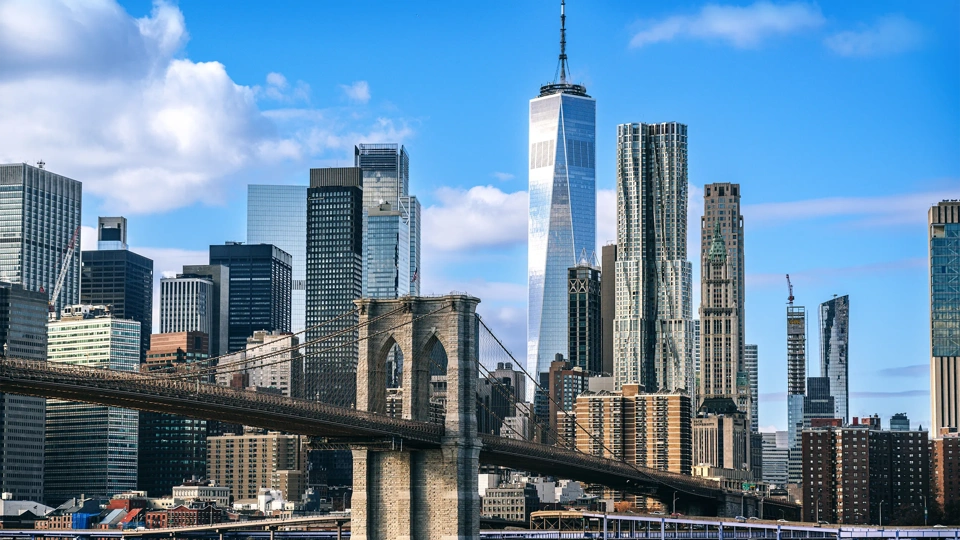 Iconic view featuring the Brooklyn Bridge against the modern New York City skyline on a clear day, showcasing the city's architectural beauty and urban energy.