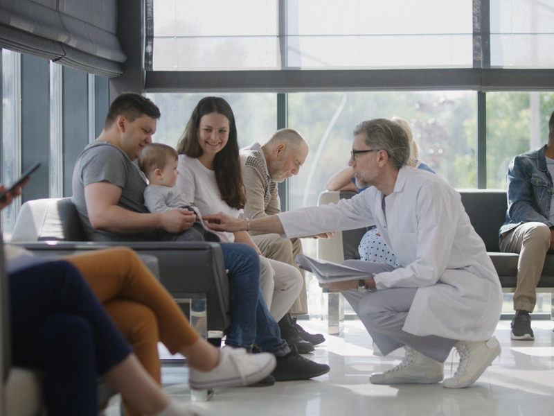 Doctor speaking to couple with baby in hospital