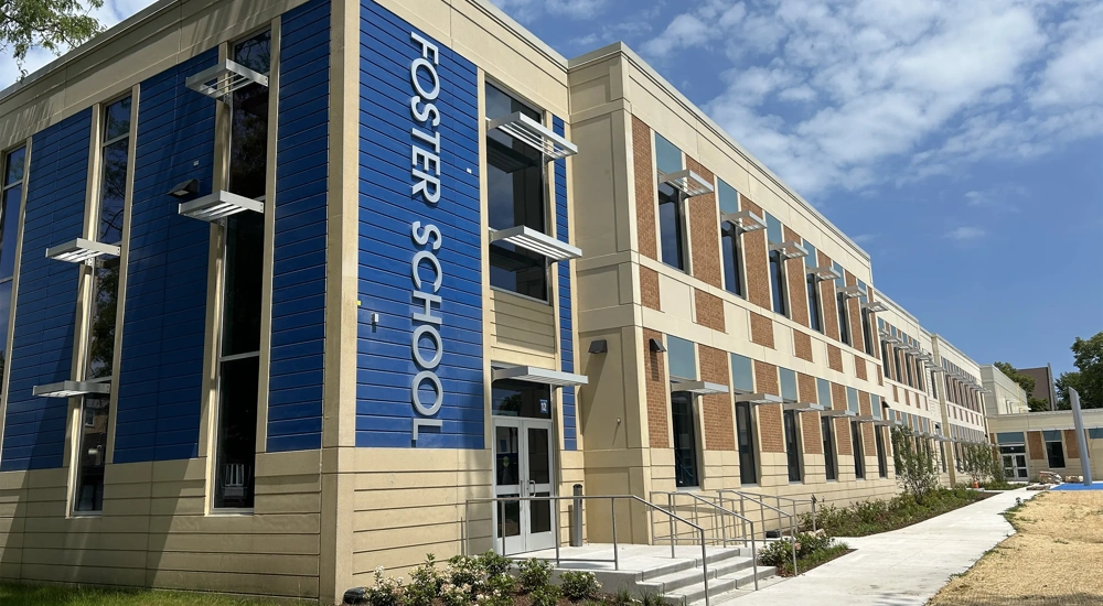 A modern building with 'Foster School' on the side, during the daytime